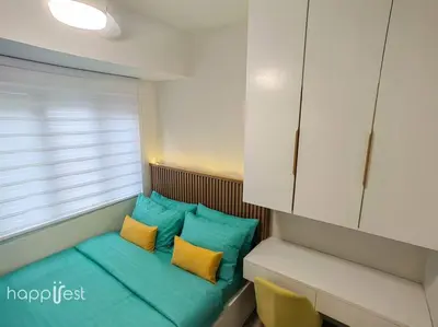 a small room with blue and yellow pillows and a window at Happirest at S Residences w/Balcony, Mall of Asia in Manila