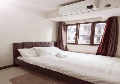 a bedroom with a large bed with a window at S Residences1 bedroom with balcony near MOA in Manila