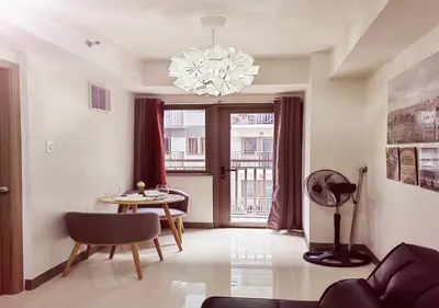 a living room with a table and a chandelier at S Residences1 bedroom with balcony near MOA in Manila