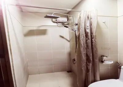 a small bathroom with a shower with a toilet at S Residences1 bedroom with balcony near MOA in Manila