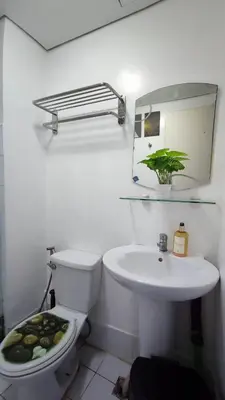 a bathroom with a sink and a toilet and a mirror at Near Manila Airport, MAILZ HOMEZ COZY 1 Bedroom Condo, Full Kitchen, Swimming Pool, WIFI, 10L in Manila