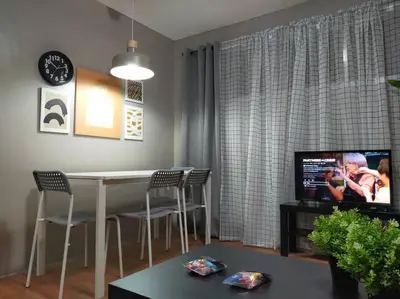 a living room with a table and chairs and a television at Stylish 2BR w/ Free Pool Access and Parking LG03 in Manila