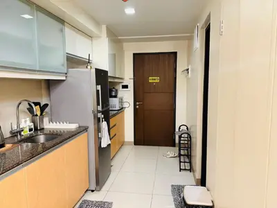 a small kitchen with a sink and a refrigerator at Modern Suite In Bonifacio Global City in Manila