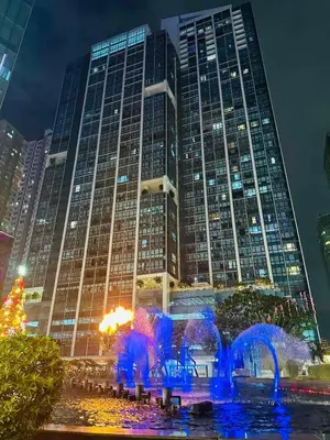a tall building with a fountain in front of it at Modern Suite In Bonifacio Global City in Manila