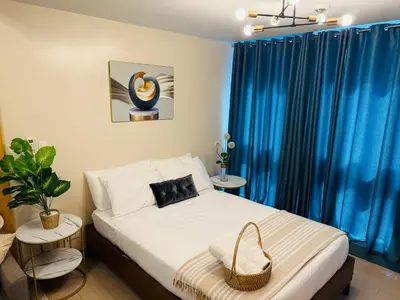 a bedroom with a bed with blue drapes at Modern Suite In Bonifacio Global City in Manila