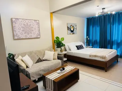 a living room with a bed and a couch at Modern Suite In Bonifacio Global City in Manila