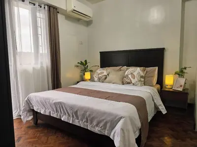 a bedroom with a large bed and a window at Acacia Estates' The Getaway Taguig Jade Tower in Manila