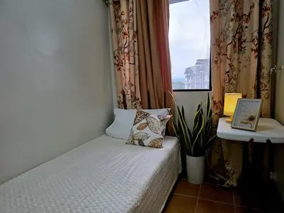 a small bed in a room with a window at Acacia Estates' The Getaway Taguig Jade Tower in Manila