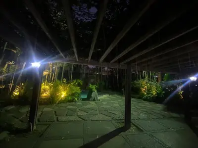 a person sitting on a patio at night with lights at Cozy 2BR w/ Free Pool Access and Free Parking N224 in Manila