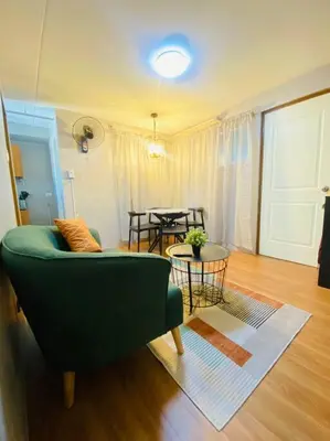 a living room with a green couch and a table at Cozy 2BR w/ Free Pool Access and Free Parking N224 in Manila