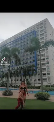 a woman standing in front of a large building at MOA Staycation - Ashti in Manila