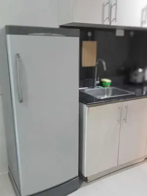 a kitchen with a sink and a white refrigerator at MOA Staycation - Ashti in Manila