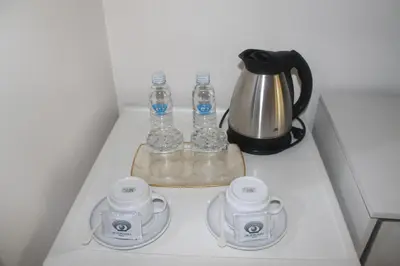 a counter with a tea kettle and two bottles of water at Pearl Manila Hotel in Manila