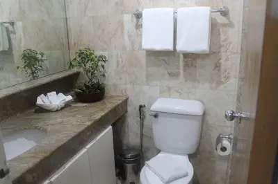 a bathroom with a toilet and a sink at Pearl Manila Hotel in Manila