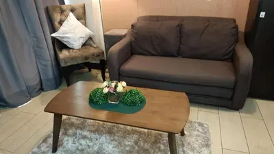 a living room with a couch and a coffee table at Condotel in front of Terminal 3 in Manila