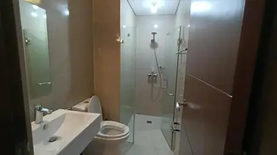 a bathroom with a shower and a toilet and a sink at Condotel in front of Terminal 3 in Manila