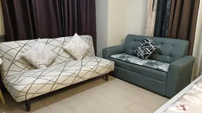 a living room with a couch and a chair at Condotel in front of Terminal 3 in Manila