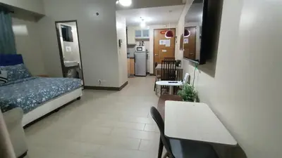 a room with a bed and a table and a kitchen at Condotel in front of Terminal 3 in Manila