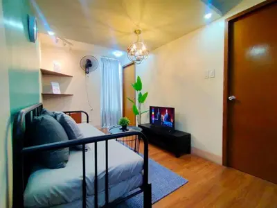 a room with a bed and a television in it at Spacious 2BR w/ Free Pool Access and Parking (709) in Manila