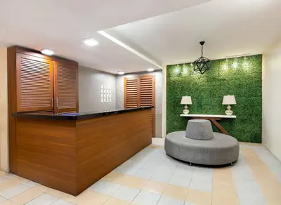 a lobby with a chair and a green wall at Spacious 2BR w/ Free Pool Access and Parking (709) in Manila
