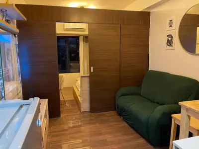 a living room with a green couch and a tub at Destina Stays, Cozy & Netflix @Air Residences, Makati, Metro Manila in Manila
