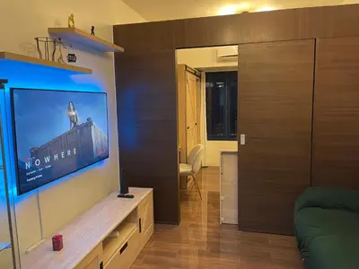 a living room with a flat screen tv on a wall at Destina Stays, Cozy & Netflix @Air Residences, Makati, Metro Manila in Manila