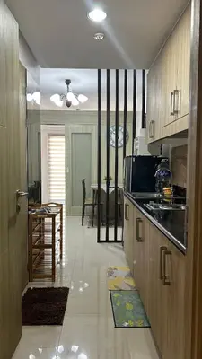 a kitchen with wooden cabinets and a table in a room at Shore Residences in Manila