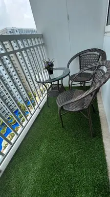 three chairs and a table on a balcony at Shore Residences in Manila