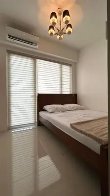 a bedroom with a bed and a chandelier at Shore Residences in Manila