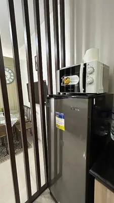 a microwave on top of a refrigerator in a kitchen at Shore Residences in Manila