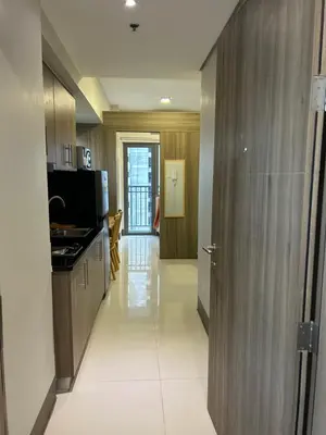 a kitchen with wooden cabinets and a hallway at Cairong Inn Condominium TV with Netflix FAME RESIDENCES in Manila