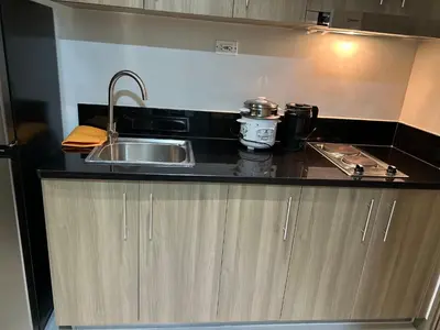 a kitchen counter with a sink and a stove at Cairong Inn Condominium TV with Netflix FAME RESIDENCES in Manila