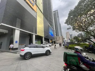 a white car parked in front of a building at Cairong Inn Condominium TV with Netflix FAME RESIDENCES in Manila