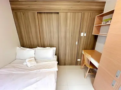 a small room with a bed and a desk at Cairong Inn Condominium TV with Netflix FAME RESIDENCES in Manila