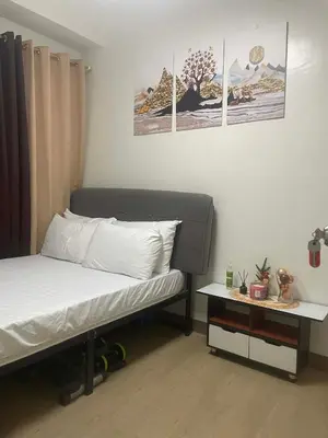 a bedroom with a bed and a side table at PARANAQUE STAYCATION at SPRING RESIDENCES T3 U1231 in Manila