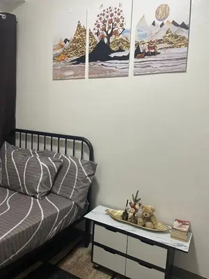 a room with a bed and three paintings on the wall at PARANAQUE STAYCATION at SPRING RESIDENCES T3 U1231 in Manila