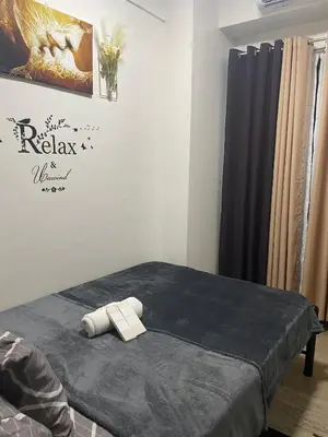 a room with a bed with a blue blanket at PARANAQUE STAYCATION at SPRING RESIDENCES T3 U1231 in Manila