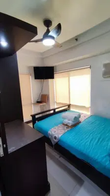 a bedroom with two beds and a ceiling fan at Near Manila Airport, MAILZ HOMEZ COZY 2 Bedroom Condo, Full Kitchen, Swimming Pool, WIFI, 4R in Manila