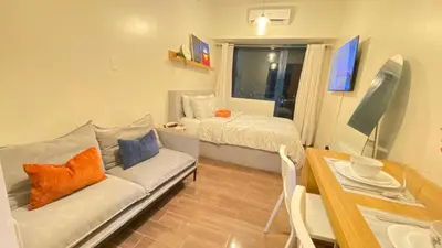 a living room with a couch and a bed at Air Residences -City View in Manila