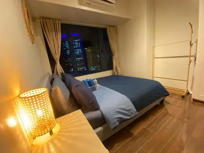 a bedroom with a bed and a couch and a window at Air Residences -City View in Manila