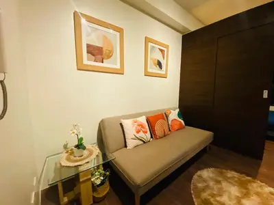 a living room with a couch and a glass table at Air Residences -City View in Manila