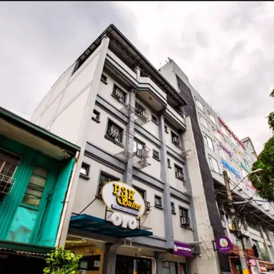 a white building with a yellow sign on it at P3K Suites Budget Hotel in Manila