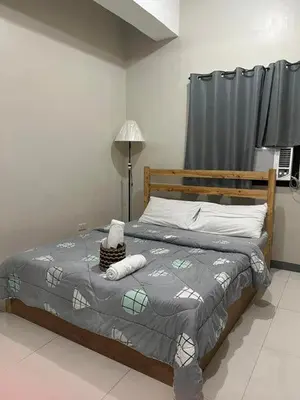 a bedroom with a bed with a gray comforter at P3K Suites Budget Hotel in Manila