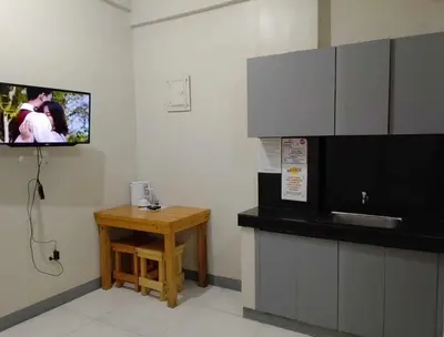 a kitchen with a tv on the wall and a table at P3K Suites Budget Hotel in Manila