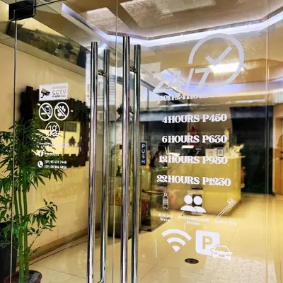 a store front door with signs on the glass at P3K Suites Budget Hotel in Manila