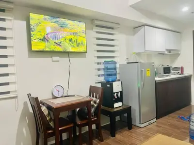 a kitchen with a table and a refrigerator at UNIT 4765 AIR in Manila