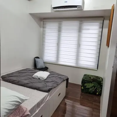 a bedroom with a bed and a window with a laptop at UNIT 4765 AIR in Manila
