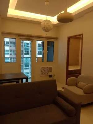 a living room with a couch and a table at Homey 1Bedroom BGC Condo - MINIMUM 2 Nights stay in Manila