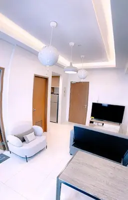 a living room with a white couch and a desk at Homey 1Bedroom BGC Condo - MINIMUM 2 Nights stay in Manila