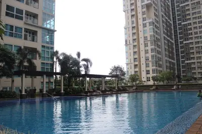 a large swimming pool in a city with tall buildings at Homey 1Bedroom BGC Condo - MINIMUM 2 Nights stay in Manila